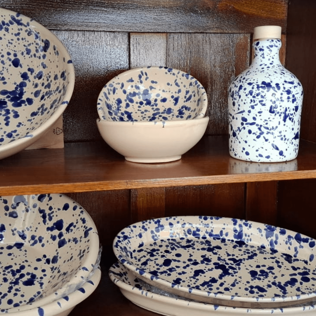 Italienische Keramikschalen und Flasche mit blauem Sprenkelmuster im Holzregal